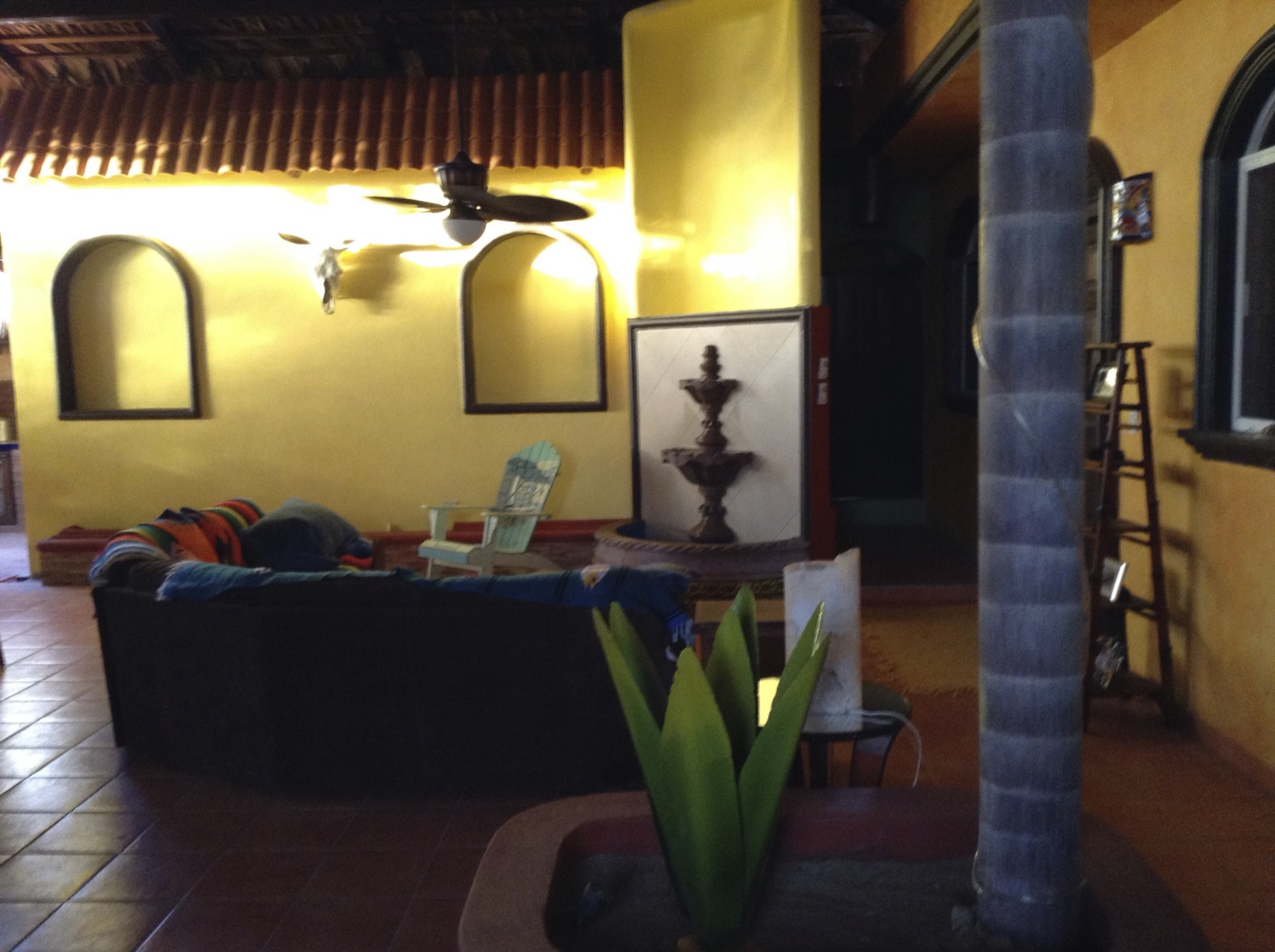 Living room with vaulted thatched ceiling, tiled roof beams, arched wall niches, and a comfortable sectional sofa